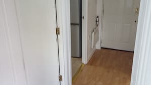 A hallway with white doors, a radiator, and wooden flooring. - Cosy London Apartment Retreat - Colindale (London)