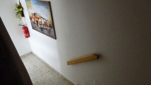 En trappa med ett ledstång, en brandsläckare och en tavla som hänger på väggen.