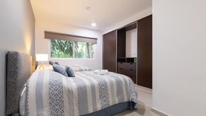 Une chambre à coucher avec un lit, une lampe de chevet, une fenêtre et une armoire.