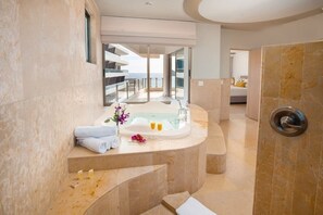 A modern bathroom with a large bathtub, a shower area, and a balcony with a view.