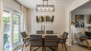 A dining area with a table, chairs, and a pendant light. - Large 4BR Home, Garage – Short & Long Stay (Pleasant Valley)