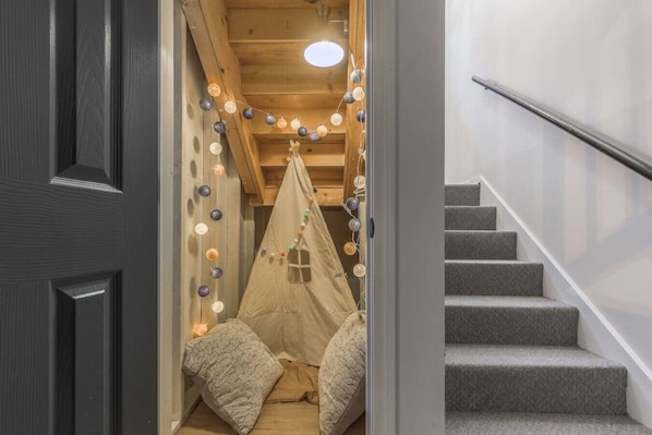 A staircase leading to a room with a tent-like structure decorated with lights.
