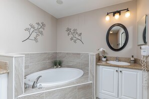 Une salle de bain avec une baignoire sur pieds, un meuble-lavabo et un miroir au-dessus du lavabo.