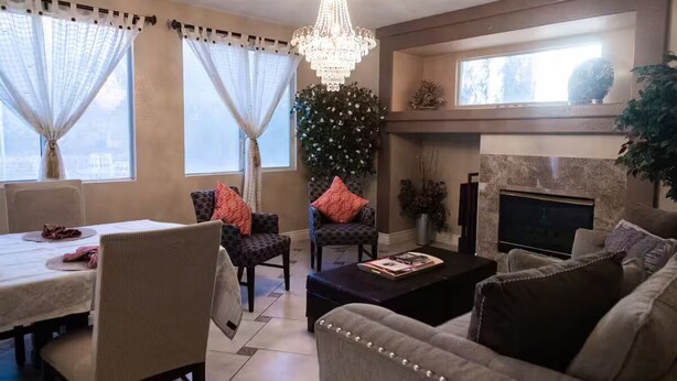 A living room with a fireplace, a chandelier, and a dining area with a table and chairs. - 4Br Perfect 3,000 SqFt HOUSE 5st (LAS VEGAS)