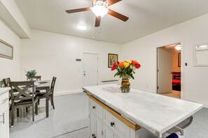 Eine moderne Küche mit Essbereich, einem Deckenventilator und einer Blumenvase auf der Arbeitsplatte.