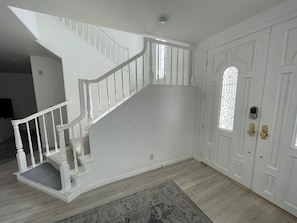 A staircase with white railings and a carpeted landing.