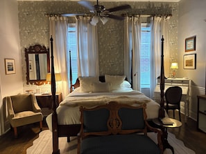 A bedroom with a four-poster bed, a desk, a chair, and a ceiling fan. - Chesnut Cottage Inn (Columbia)