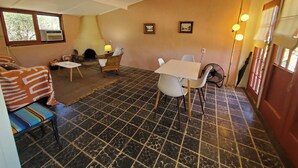Une pièce chaleureuse avec une cheminée, une table à manger et un canapé.