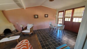 Une pièce comprenant une table à manger et des chaises, un canapé, un tapis à motifs et un lit.