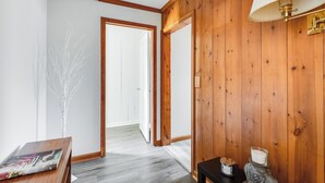 Un passadís amb parets de fusta, una porta blanca i una làmpada.