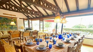 Un coin repas avec une nappe à carreaux, des chaises en bois et de la verrerie bleue.