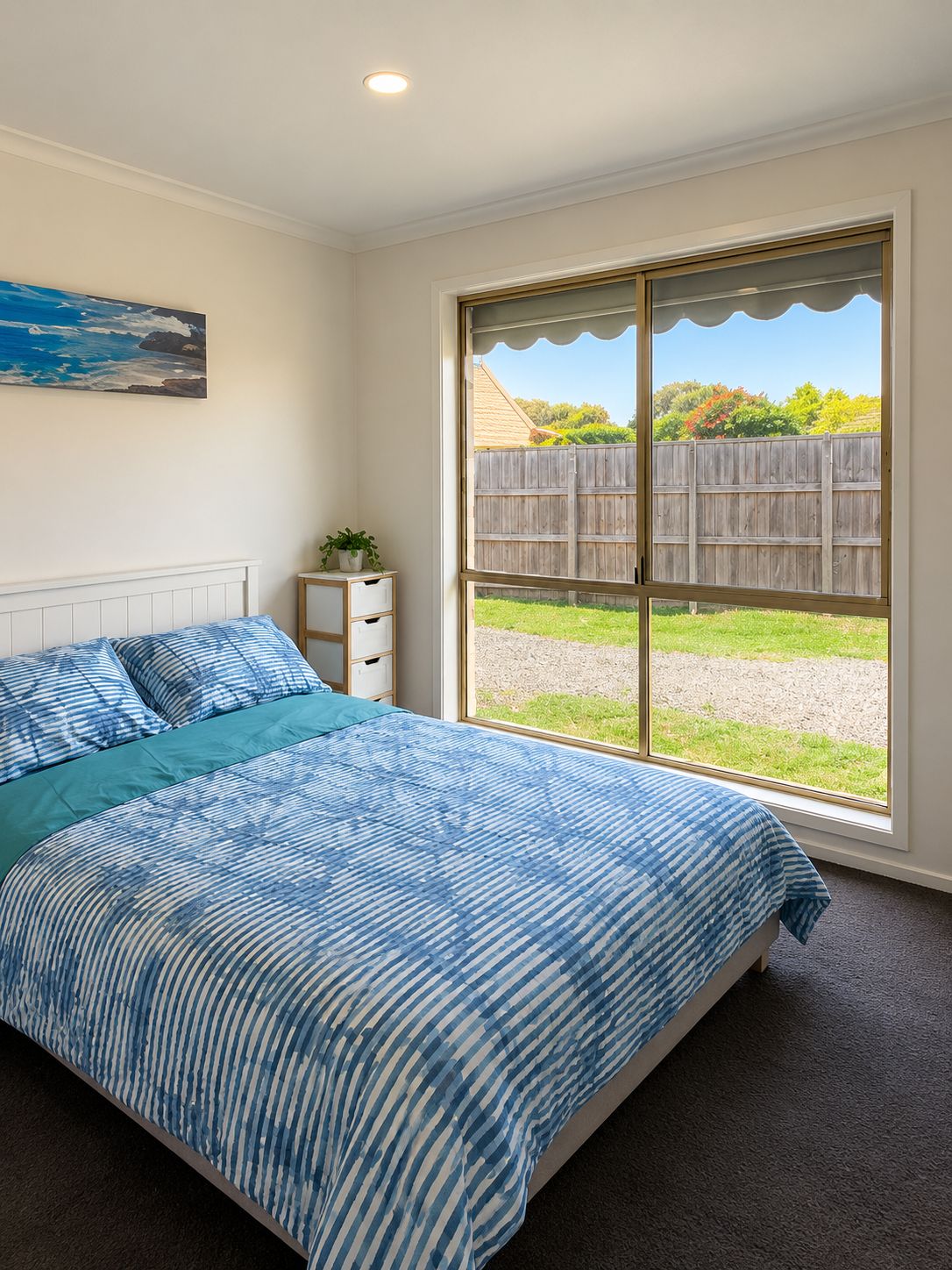 Une chambre avec un grand lit, une fenêtre et une vue sur un jardin.