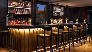 A bar area with multiple liquor bottles, bar stools, and a wooden bar counter. - Stockton Inn (Stockton)