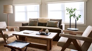 A cozy living room with a sofa, armchairs, a coffee table, and a lamp. - Stockton Inn (Stockton)
