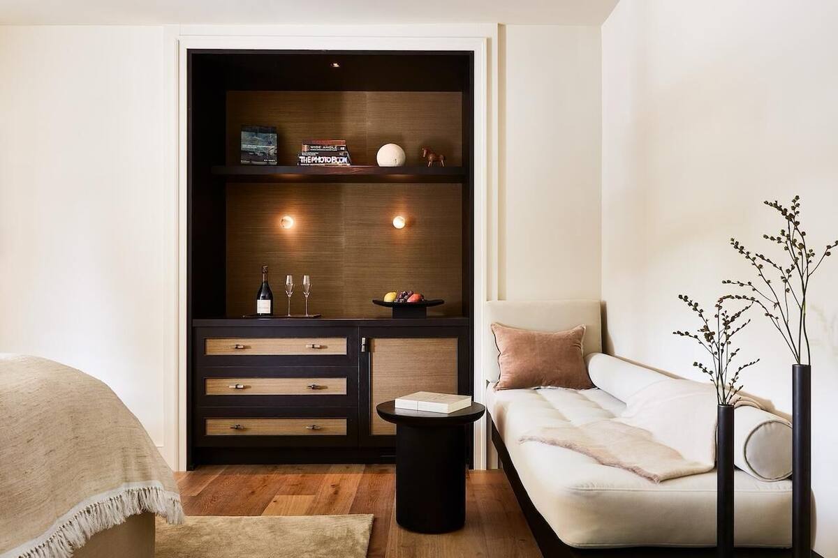 Ein modernes Wohnzimmer mit einer Couch, einem Couchtisch, einem Bücherregal und einer dekorativen Vase.