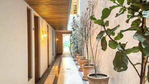 A corridor with a wooden ceiling, potted plants, and a tiled floor. - Lasai Casa Puebla  (Mexico City)