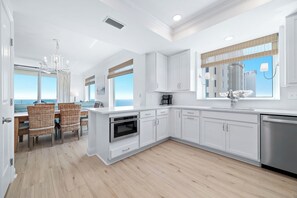 A modern kitchen with white cabinetry, a built-in oven, and a dishwasher.