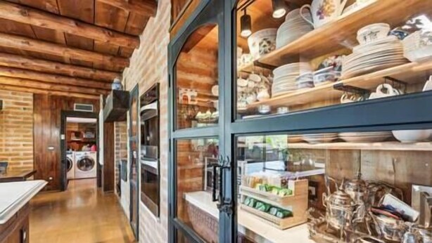 A corridor with wooden walls and a glass display case filled with dishes and kitchenware. - "Scarritt House"  Small Deluxe Blue Bedroom. (Tucson)