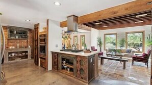 A spacious living area with a large kitchen, a fireplace, and a view of the outdoors. - Rancho Bonito "Beautiful Ranch" (Tucson)