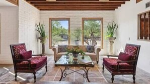A cozy indoor seating area with a wooden ceiling, two armchairs, a sofa, and a coffee table. - Rancho Bonito "Beautiful Ranch" (Tucson)