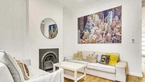 Una sala de estar moderna con un sofá blanco, una mesa de centro y una chimenea.