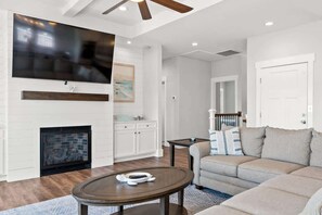 A living room with a fireplace, a television mounted on the wall, a sofa, and a coffee table.