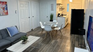 A compact living space with a sofa, dining table, chairs, a small kitchen area, and a TV. - DEPARTAMENTO PARA 5 (Ciudad Juárez)