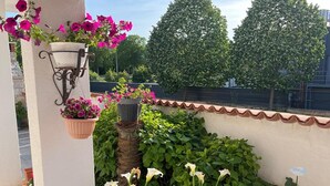 A covered patio area with potted plants and flowers, a wooden ceiling, and a white wall. - Apartment 2366/123283 (Istria - Rovinj), 1500m from the beach (Rovinj)