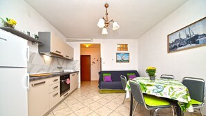 A compact kitchen with modern appliances, a dining area with a table and chairs, and a cozy seating area with a sofa. - Apartment 2366/123283 (Istria - Rovinj), 1500m from the beach (Rovinj)