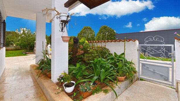 A covered patio with potted plants, a metal gate, and a clear blue sky. - Apartment 2366/123283 (Istria - Rovinj), 1500m from the beach (Rovinj)