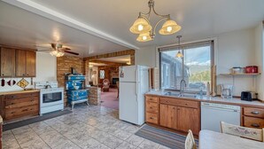A kitchen with wooden cabinets, a stove, a refrigerator, and a window with a view. - Casa Commodore ~ Paddles, Pups & Proximity! (Salida)