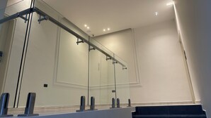 Una escalera moderna con barandillas de vidrio y un diseño minimalista.