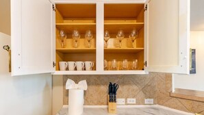 A kitchen with white cabinets, marble countertops, and a knife block. - Chic, Comfortable Home Steps from SXSW Fun (Buda)