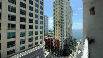 A high-rise building with multiple floors, large windows, and a view of the sea.