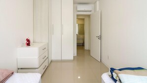 Een slaapkamer met een bed, een kaptafel en een kledingkast.