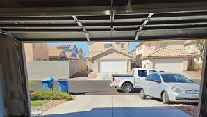 A garage with a concrete floor, a white truck parked inside, and a silver car parked outside. - Great Specials Now! PET Friendly, 2 Bedroom, 2 Bath Home, 10 min. from The Strip (Las Vegas)