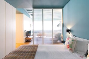 A modern hotel room with a large bed, a TV, and a view through a sliding door to a balcony. - HM - Infante Riverside Apartment M (Porto)