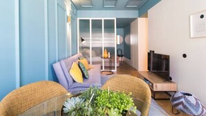 A modern living room with a sofa, coffee table, and chairs. There is a TV and a fireplace. - HM - Infante Riverside Apartment M (Porto)