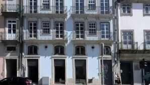 A multi-story building with a central entrance, balconies, and a cobblestone street. - HM - Infante Riverside Apartment M (Porto)