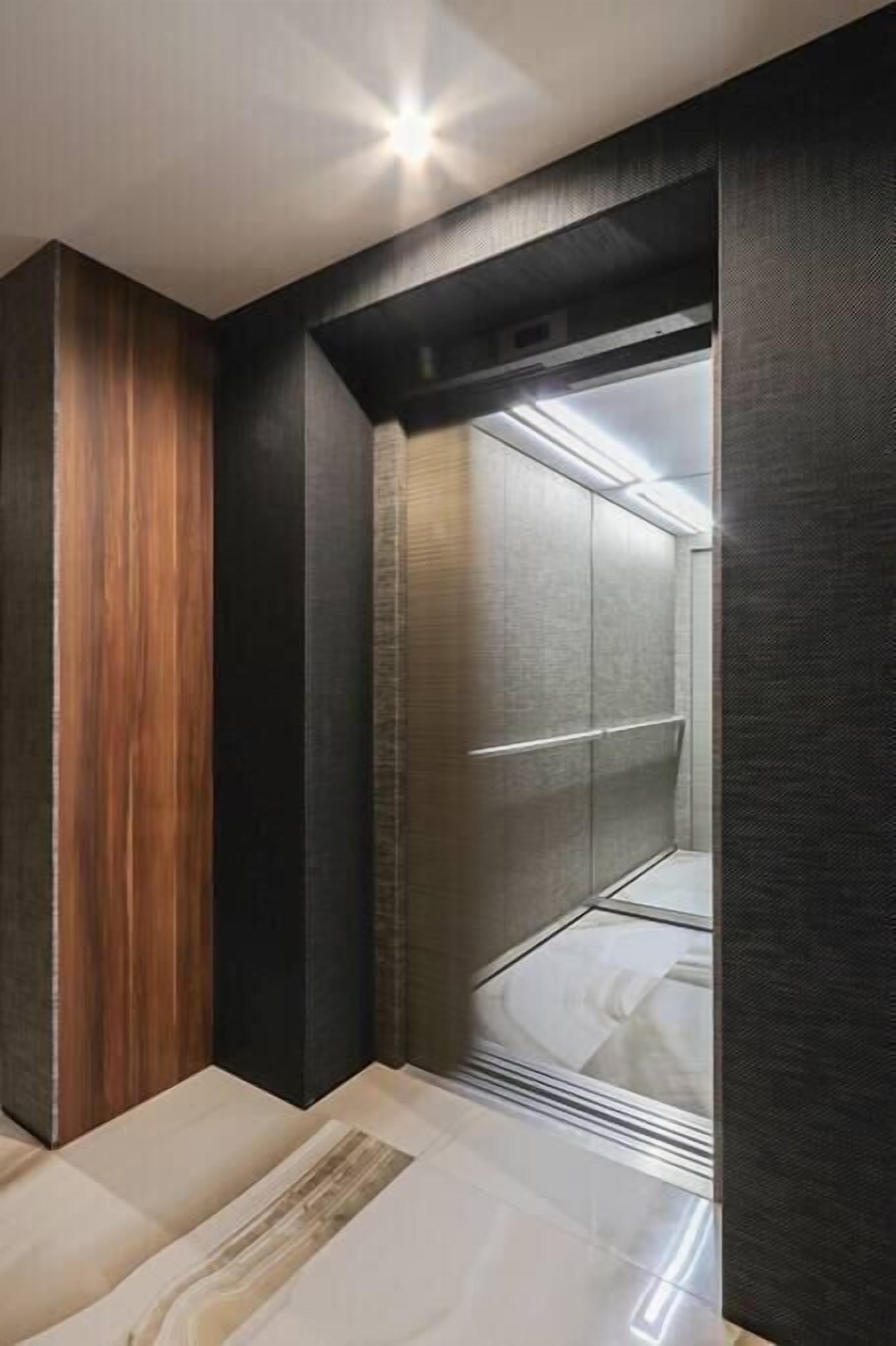 Ein modernes Zimmer mit einer Holzwand, einem großen Spiegel und einem eleganten, dunkel gefärbten Kleiderschrank.