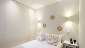 Une chambre à coucher avec un lit, des tables de chevet et une armoire.