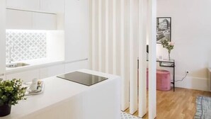 Una cocina moderna con armarios blancos, una isla central e iluminación colgante.