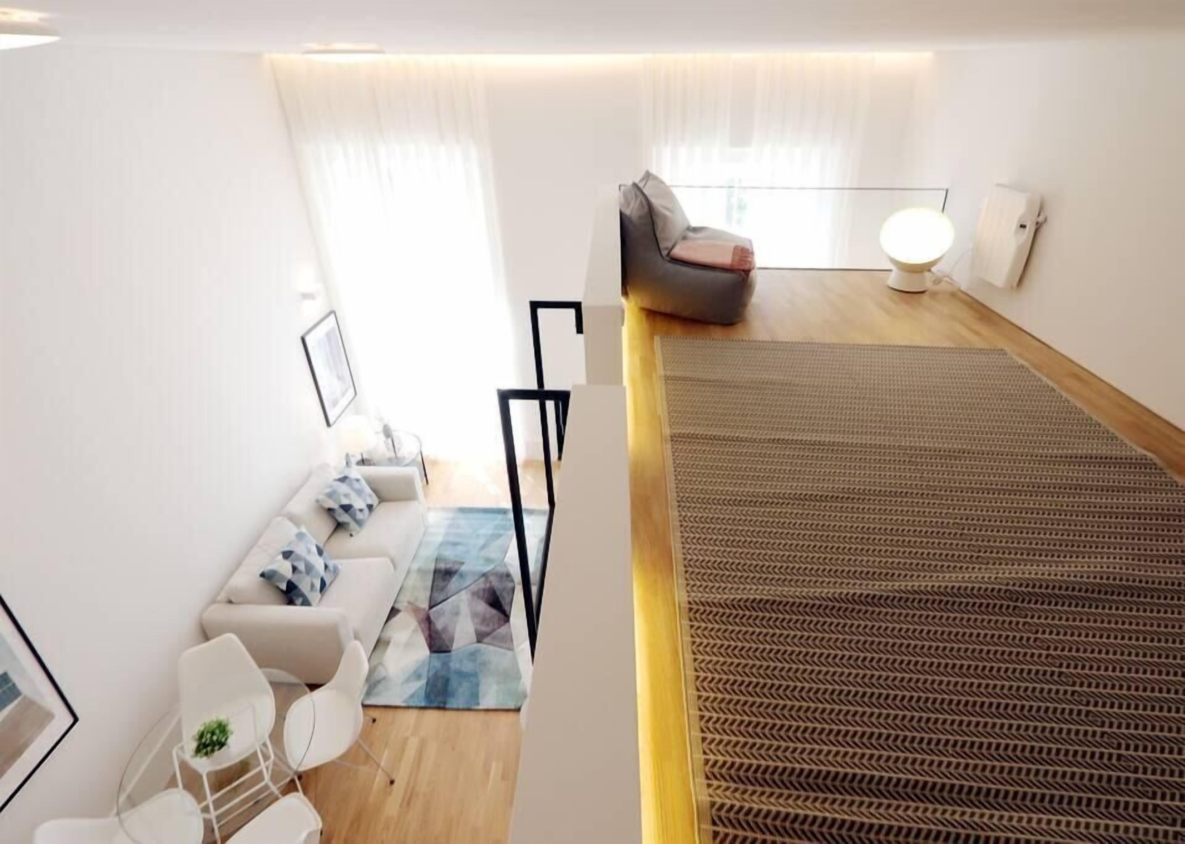 Un salon moderne avec un canapé, des fauteuils et un tapis à motifs.