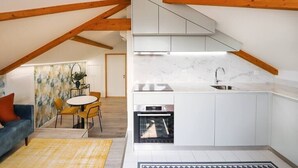 A modern kitchen with white cabinets, a built-in oven, and a marble countertop. - HM - Home Feeling Studio Campanhã (Porto)