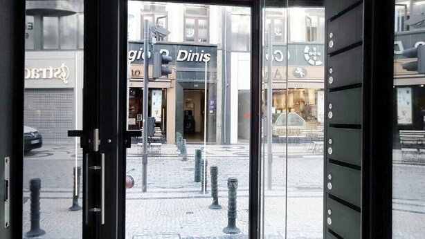 An entrance to a building with a glass door, a sign for 'Dinis', and a cobblestone street outside. - HM - Sta Catarina Charming Apartment (Porto)