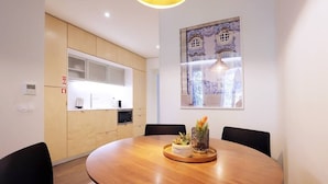 Un comedor moderno con una mesa redonda de madera, sillas negras y un centro de mesa decorativo.
