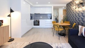 Un appartement moderne comprenant une cuisine, un coin repas et un salon.