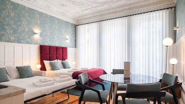 A hotel room with a bed, a sofa, a dining table, and chairs. - HM Loios charming loft (Porto)
