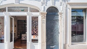 A boutique jewelry store with a classic facade, a large arched entrance, and a decorative metal door. - HM Loios charming loft (Porto)