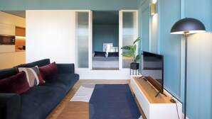 Ein modernes Wohnzimmer mit einer Couch, einem Fernseher und einer Pflanze.
